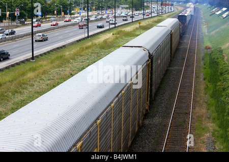 Un train en marche à côté d'une autoroute à Toronto, Ontario, Canada. Banque D'Images