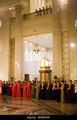 Audience de la femme en costume national à l'ouverture de conférence internationale dans le Musée du Président, Ashqabat, Turkménistan Banque D'Images