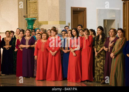 Audience de la femme en costume national à l'ouverture de conférence internationale dans le Musée du Président, Ashqabat, Turkménistan Banque D'Images