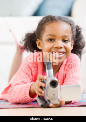 Mixed Race girl holding caméra vidéo Banque D'Images