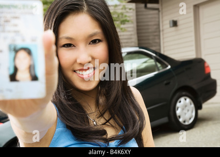 Adolescent asiatique montrant fièrement nouveau permis de conduire Banque D'Images