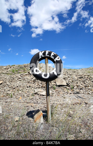 Barbelés avec pneus sign painted garder hors près de Pincher Creek, Alberta, Canada Banque D'Images