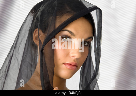 Beau portrait d'une jeune femme avec un voile noir sur la tête. Banque D'Images