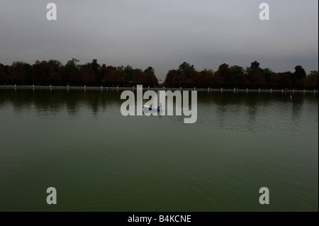 Un seul bateau à rames sur le lac dans le parc du Retiro en automne à Madrid en Espagne. Banque D'Images