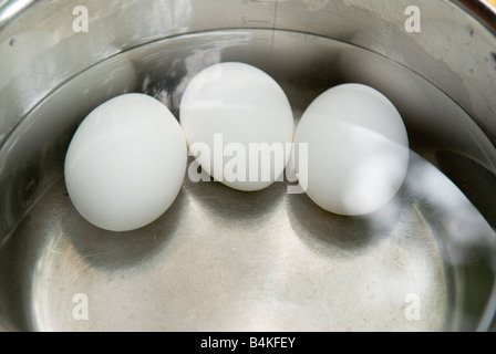 Trois oeufs durs dans une casserole. Banque D'Images