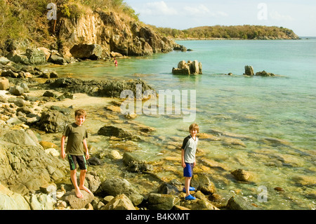 Garçons jouant sur les rochers à proximité d'un Lamshur Bay Beach à Saint John, USVI Banque D'Images