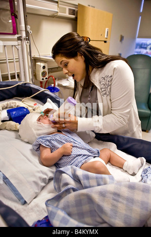 Dans un hôpital de Californie une mère prend soin de son bébé souffrant de moelle bifida Remarque condition monitoring EEG Banque D'Images