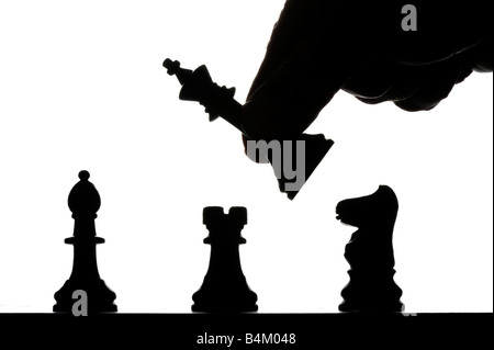 Main mâle déménagement pièces des échecs silhouetté sur chess board Banque D'Images