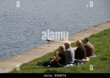 Quatre touristes par le lac padarn relaxant, Llanberis, Pays de Galles, Grande-Bretagne Banque D'Images