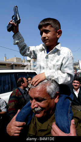 Un gouvernement irakien anti-américain parrainé de démonstration sur une rue de Bagdad avant l'invasion menée par les Etats-Unis Notre photo montre l'Anti guerre à Bagdad comme jeune garçon pistolet de son père vagues Banque D'Images
