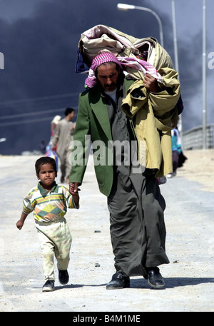 Guerre en Irak 2003 habitants de fuir la ville de gravure de Bassorah dans le sud de l'Iraq comme éléments blindés des Royal Scots Dragoon Guards atteindre les jupes de la ville Banque D'Images