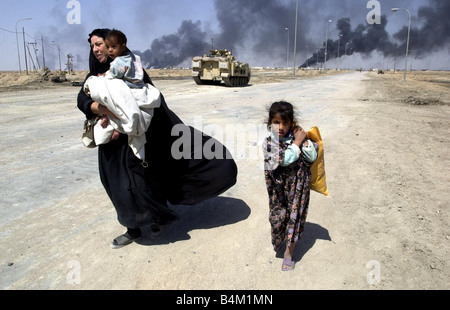 Guerre en Irak Mars 2003 habitants de fuir la ville de gravure de Bassorah dans le sud de l'Iraq comme éléments blindés des Royal Scots Dragoon Guards atteindre les jupes de la ville Banque D'Images