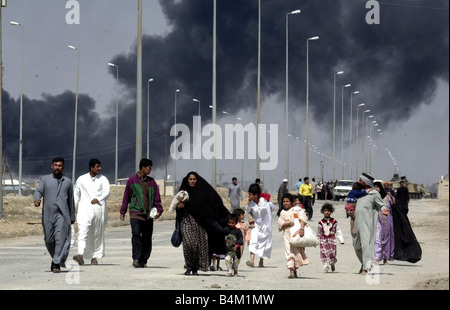 Guerre en Irak 2003 habitants de fuir la ville de gravure de Bassorah dans le sud de l'Iraq comme éléments blindés des Royal Scots Dragoon Guards atteindre les jupes de la ville Banque D'Images