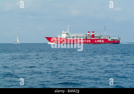 La coque rouge Goutos Lines Ferry Macédoine passant près de Voukari Yacht dans la mer Egée à l'île de Kéa Cyclades Grèce Banque D'Images