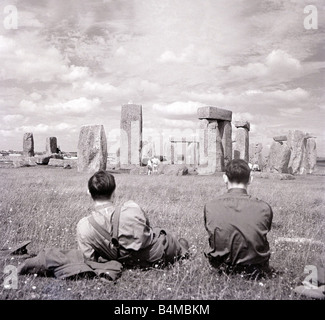 L'un des plus célèbres de Grande-Bretagne et mystérieux Stonehenge monuments anciens dans la plaine de Salisbury Wiltshire deux hommes regarder le monument druidique où les pèlerins viennent pour adorer pendant l'été la campagne pittoresque Scène Solstic Pays des pierres disposées en cercle vers 1930 Banque D'Images