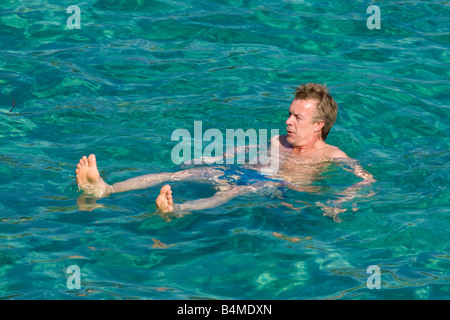 Un homme nage dans la baie méditerranéenne de l'Escalet à la Côte d'Azur / Provence / Sud de la France Banque D'Images