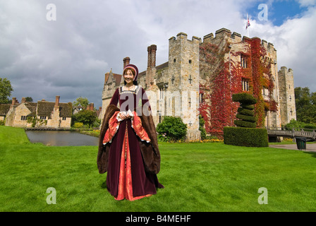 Grand angle horizontal de l'extérieur du château de Hever avec une dame habillée en Anne Boleyn marcher à l'extérieur, au soleil. Banque D'Images