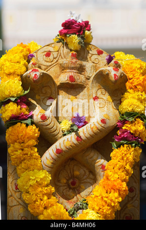 Naga. Cobra indien idoles de pierre déité couverte de guirlandes de fleurs pour la cérémonie de puja hindoue. Puttaparthi, Andhra Pradesh, Inde Banque D'Images