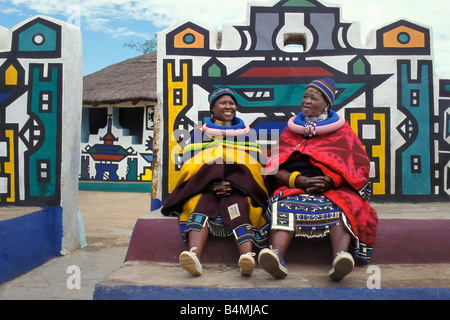 L'Afrique du Sud. Village Ndebele Mapoch peintures murales traditionnelles. Les femmes avec des vêtements traditionnels et de décoration Banque D'Images