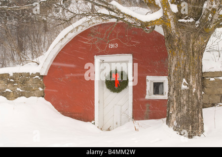 Une ancienne cave à racine rouge avec une couronne de Noël, pendant une tempête Banque D'Images