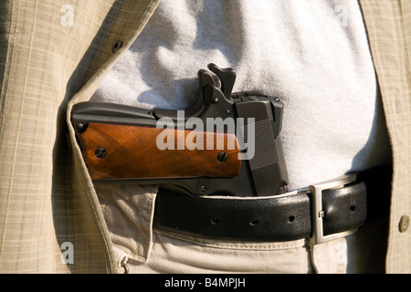Un pistolet se trouve dans la ceinture d'un homme. Banque D'Images
