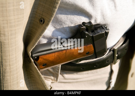 Un pistolet se trouve dans la ceinture d'un homme. Banque D'Images