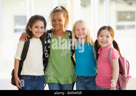 Quatre étudiants en dehors de l'école ensemble permanent smiling (high key) Banque D'Images