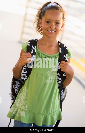 Student standing outdoors smiling (high key) Banque D'Images