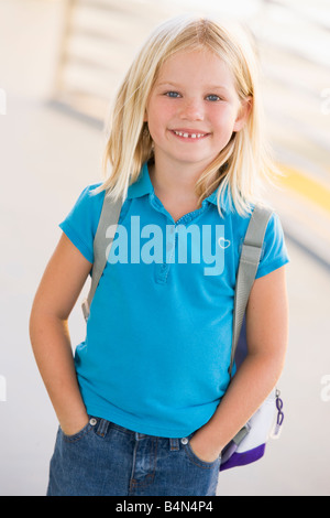 Student standing outdoors smiling (high key) Banque D'Images