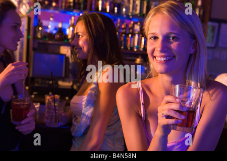 Jeune femme dans un bar avec des amis Banque D'Images