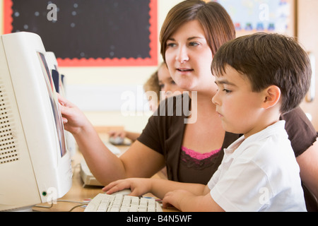 Étudiants en classe devant un ordinateur avec l'enseignant (selective focus) Banque D'Images