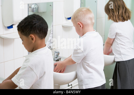 Les élèves dans la salle de bains à se laver les mains des puits Banque D'Images