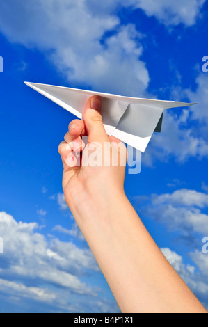 S enfant main tenant un avion en papier sur fond de ciel bleu Banque D'Images