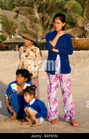 Une femme de pêcheur et la famille attendre son retour en toute sécurité après une nuit de pêche en mer, plage de Mui Ne, Vietnam Banque D'Images