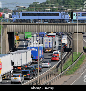 Transport Choice M25 autoroute nez à queue trafic lent regardant le train rapide de voyageurs sur le pont ferroviaire sortie 28 Brentwood Essex Angleterre Royaume-Uni Banque D'Images