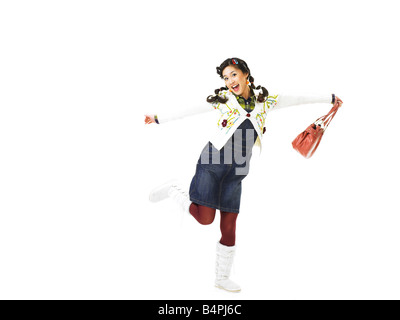 Young woman holding purse, smiling, portrait Banque D'Images