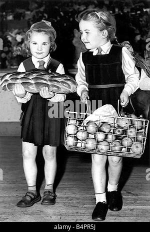 Harvest Festival deux des enfants qui arrivent avec des cadeaux fête des moissons à Edgefield École Primaire Fawdon Duggua Hilary sont âgés de cinq ans et Susan Kinner âgé de 6 Banque D'Images