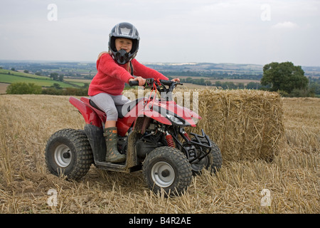 Jeune fille à cheval son champ de chaumes en quad Banque D'Images