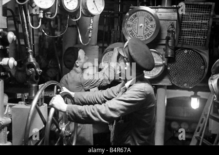 La vie à bord d'une corvette de la Marine royale l'escorte d'un convoi à travers l'Atlantique à la hauteur de l'offensive contre le bateau U Royaume-Uni en août 1942 Notre photo montre le chef mécanicien aux commandes dans la salle des machines ol568a Décembre 1942 Banque D'Images