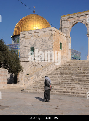 Un Arabe homme marche seul dans le soleil du midi à côté du Dôme du rocher dans la vieille ville de Jérusalem. Banque D'Images