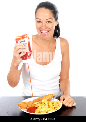 Jeune femme de mettre du ketchup sur le poisson et frites parution modèle Banque D'Images