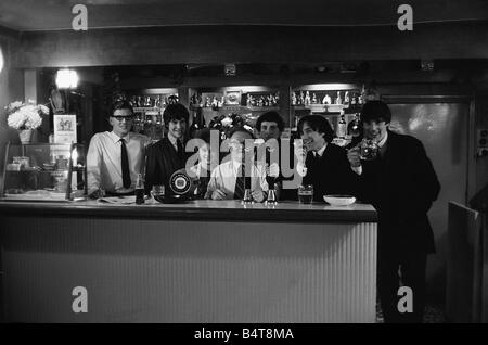 The Kinks pop group Septembre 1964 Ray Davies et Dave Davies dans un bar bénéficiant d'une pinte de bière avec le propriétaire Banque D'Images