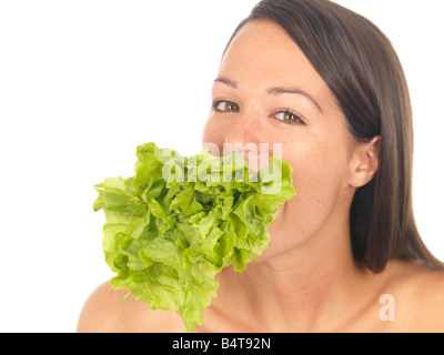 Jeune femme tenant en bonne santé et de manger de la laitue fraîche isolé sur un fond blanc avec un chemin de détourage Banque D'Images