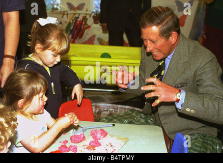 Le Prince de Galles des blagues avec les enfants âgés de deux à gauche Lauren Davies et Alison M. McFarlane a aussi deux ans lors de sa visite à l'Apple Tree Nursery à Rothesay Ecosse vendredi Banque D'Images