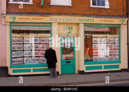 Jeune femme à la fenêtre dans des maisons Waveney Agents immobiliers pour les maisons en vente à Bungay, Suffolk, Royaume-Uni Banque D'Images