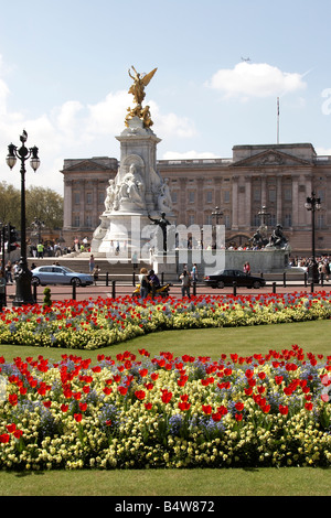 Des massifs de fleurs et les touristes en face de l'Édifice commémoratif Victoria Buckingham Palace SW1 London England Banque D'Images