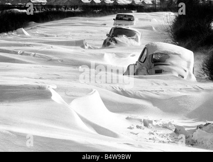 Pris au piège : Ces véhicules ne sont qu'à 800 mètres de l'Afrique du Warwickshire village de Long Itchington sur la route de Leamington, mais des bancs de neige plus de 6 pieds de profondeur dans les endroits les tient rapidement dans leurs pistes.;11 février 1985. Banque D'Images