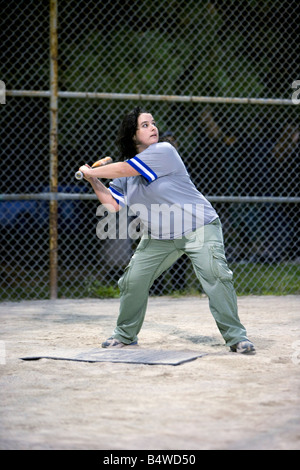 Une jeune femme se balancer une batte de baseball. Banque D'Images