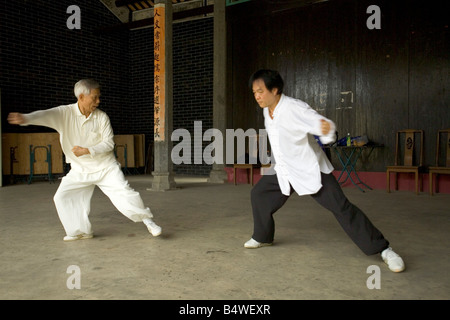 Deux hommes pratiquant l'art martial de taijiquan style Chen avec l'enseignant dans tout blanc. Banque D'Images