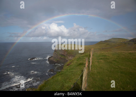 Arc-en-ciel sur les falaises sur la route côtière de la chaussée nord antrim county antrim irlande du nord uk Banque D'Images